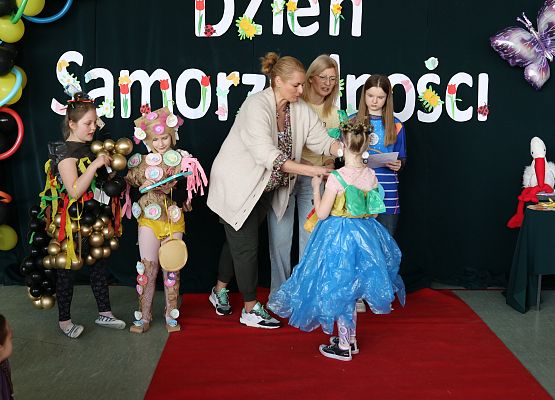 uczennica odbiera dyplom i nagrodę