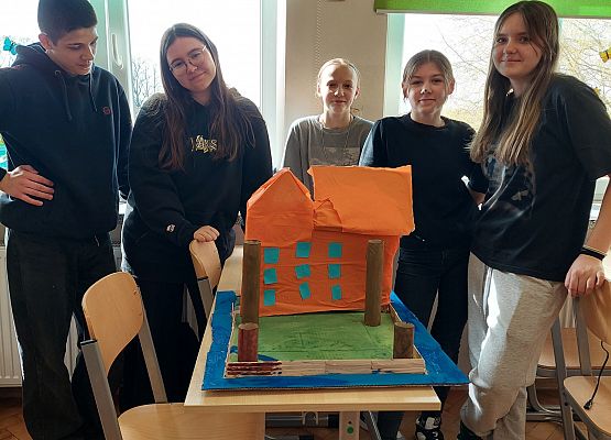 Uczniowie stoją obok makiety