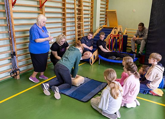 uczniowie wykonują zadanie z pierwszej pomocy przedmedycznej w obecności nauczycielki i pielęgniarki