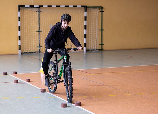 uczeń na rowerze wykonuje zadanie