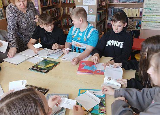 Uczniowie pracują z książką