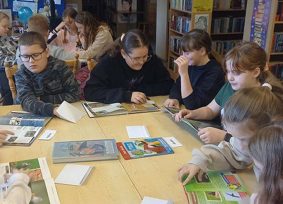 Uczniowie szukają informacji w książkach