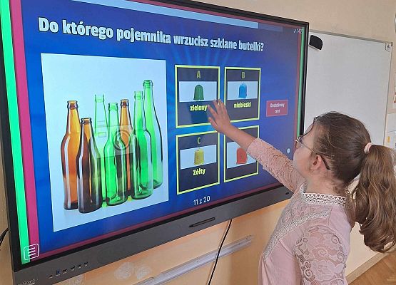 dziewczynka wykonuje zadanie dotyczące segregacji odpadów