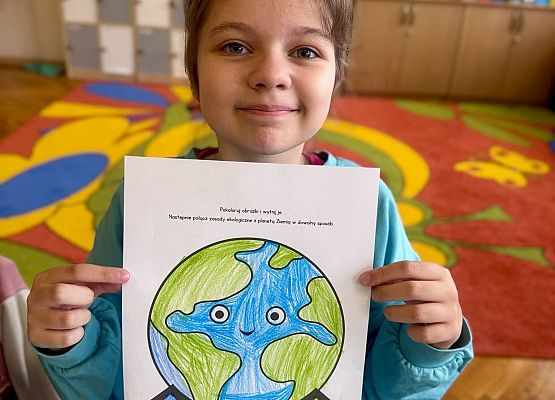 dziewczynka prezentuje swoją pracę plastyczną