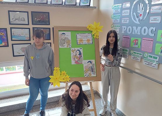 uczniowie wykonują dekorację w szkolnym holu