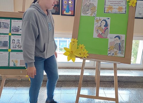 uczennica ogląda prace plastyczne uczniów