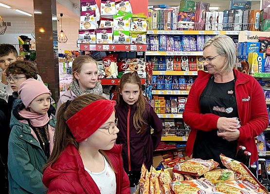 sprzedawczyni opowiada uczniom o swojej pracy