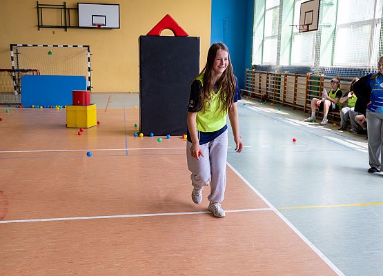 uczniowie w sali gimnastycznej  grają w paintballa