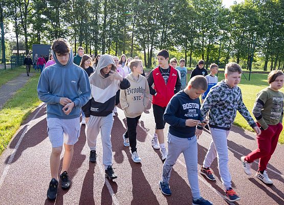 uczestnicy porannego marszu na szkolnym boisku