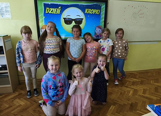 uczniowie stoją przed monitorem