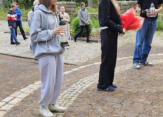 uczniowie składają kwiaty