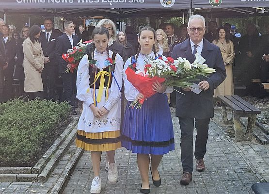 uczennice w stojach kaszubskich i pan dyrektor składają kwiaty