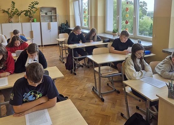 uczniowie siedzą w ławkach