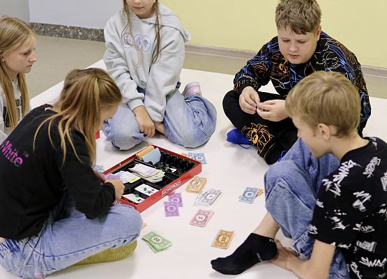 uczniowie grają w grę planszową