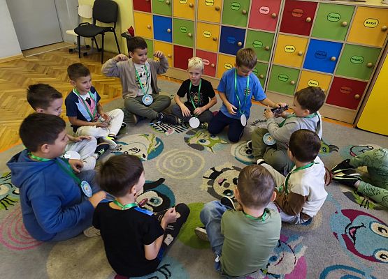 chłopcy siedzą na dywanie