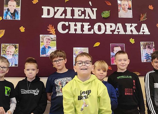 chłopcy na tle gazetki z napisem dzień chłopaka