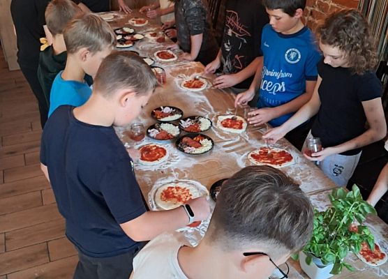 uczestnicy wycieczki  podczas robienia pizzy