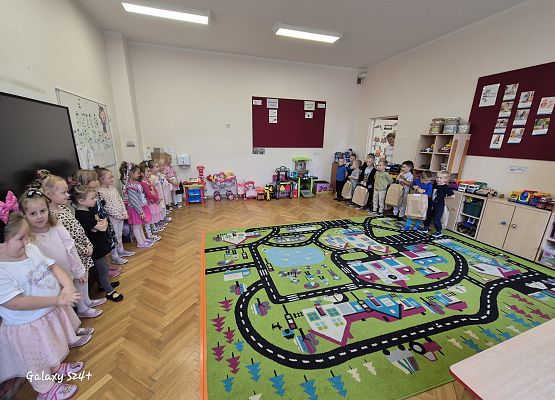 dzieci stoją w sali przedszkolnej