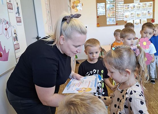 nauczycielka wręcza dyplom