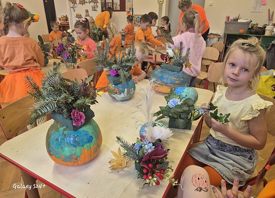 przedszkolaki wykonują kolorowe, jesienne kompozycje