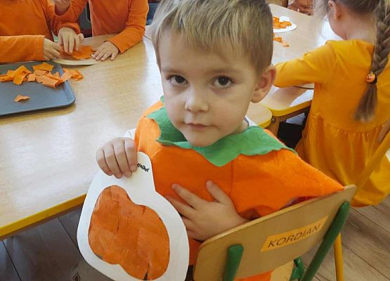 chłopiec prezentuje swoją pracę plastyczną