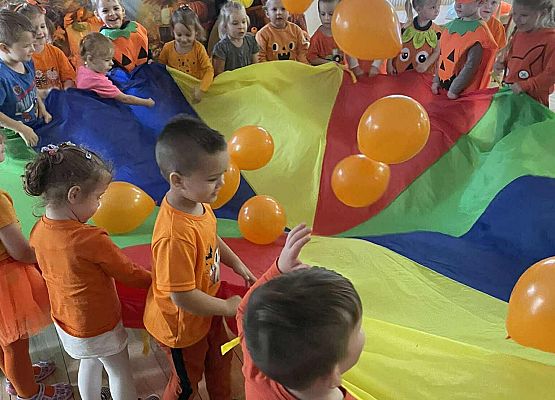 przedszkolaki podczas zabawy chustą animacyjną i balonami