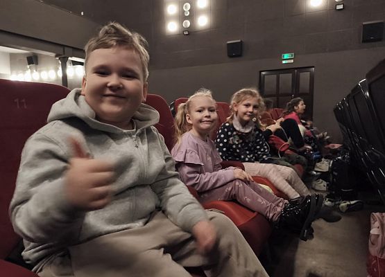 uczniowie siedzą w kinie