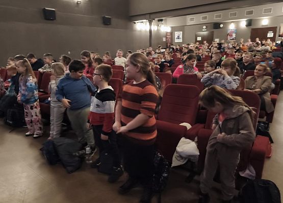 uczniowie zajmują miejsca w kinie