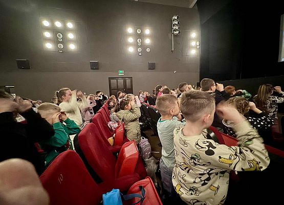 uczniowie siedzą w kinie