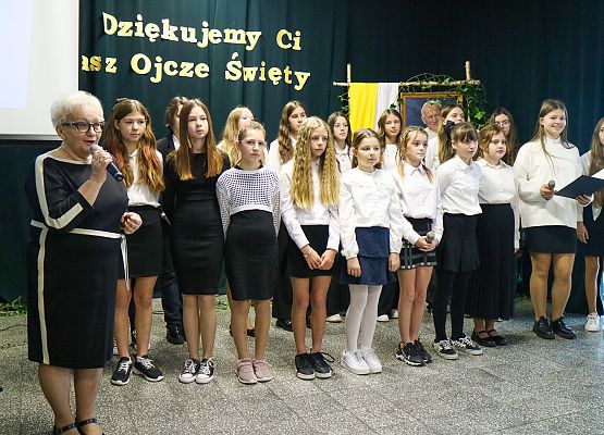 nauczycielka przemawia, uczniowie stoją na scenie