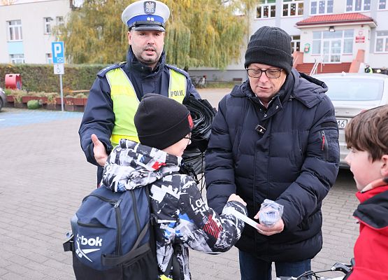 dyrektor zakłada uczniowi opaskę odblaskową