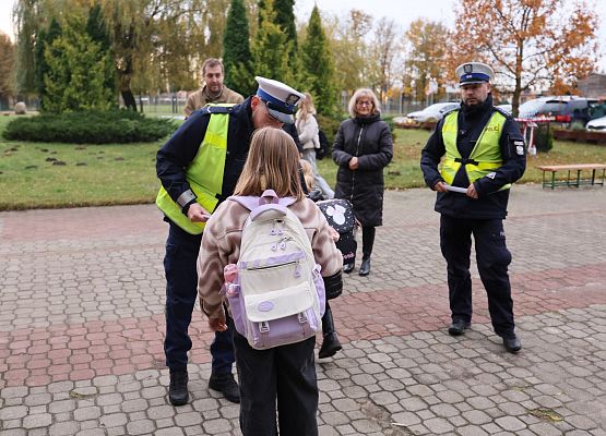 policjanci rozdają dzieciom materiały odblaskowe