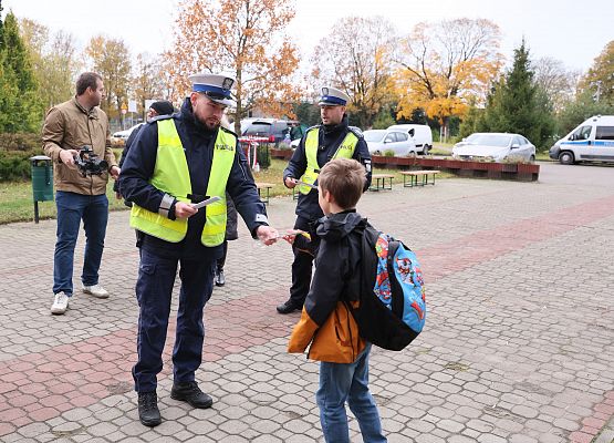 policjanci rozdają dzieciom materiały odblaskowe