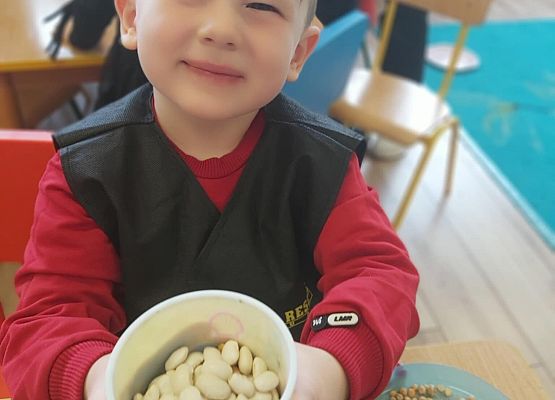 chłopiec pokazuje ile wybrał ziarenek