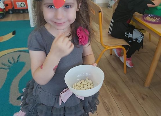 dziewczynka trzyma miseczkę z ziarenkami