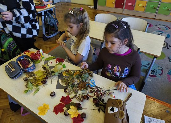 uczennice wykonują prace plastyczne z jesiennych liści