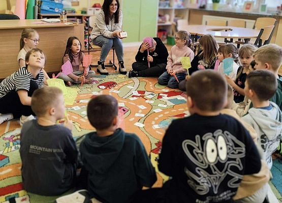 dzieci wykonując zadania bawią się na dywanie