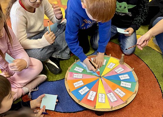 dzieci wykonując zadania bawią się na dywanie