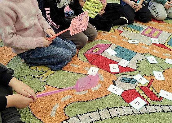 dzieci wykonując zadania bawią się na dywanie