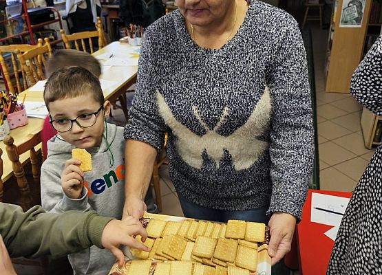 bibliotekarka rozdaje dzieciom ciasteczka