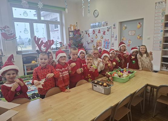 dzieci siedzą przy stole podczas zajęć