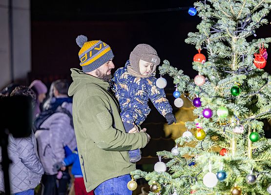 uczestnicy wydarzenia wspólnie ubierają choinkę