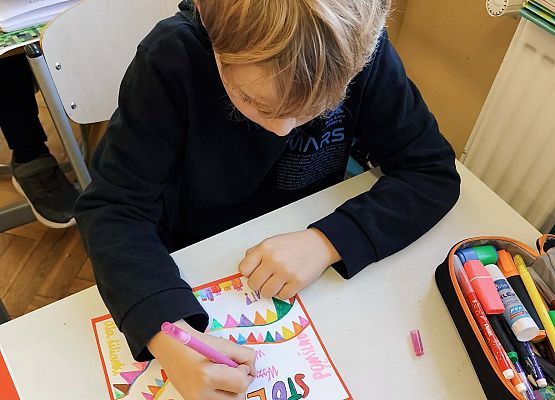 chłopiec wykonuje kartkę