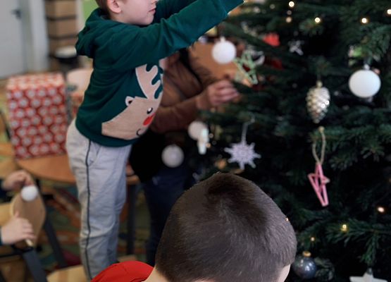 uczniowie ubierają choinkę
