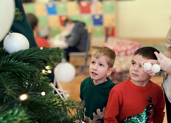 uczniowie ubierają choinkę