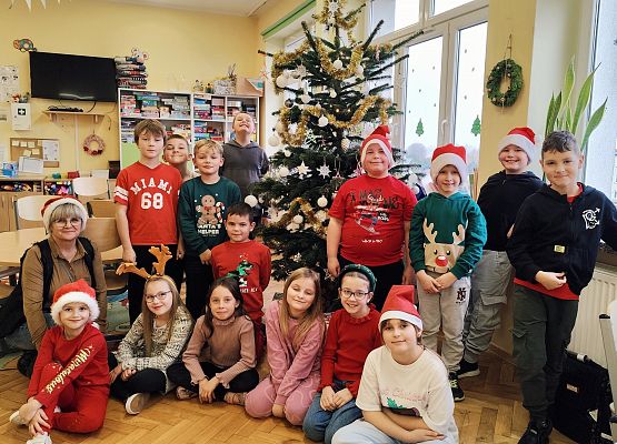 uczniowie stoją przy choince