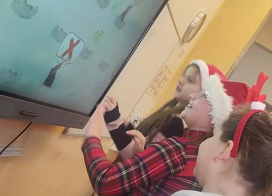 uczniowie przy tablicy multimedialnej