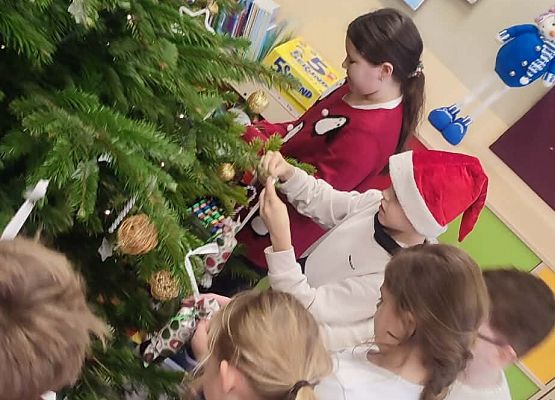 uczniowie ubierają choinkę