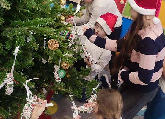 uczniowie ubierają choinkę