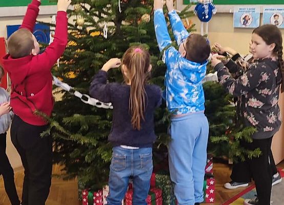 uczniowie ubierają choinkę